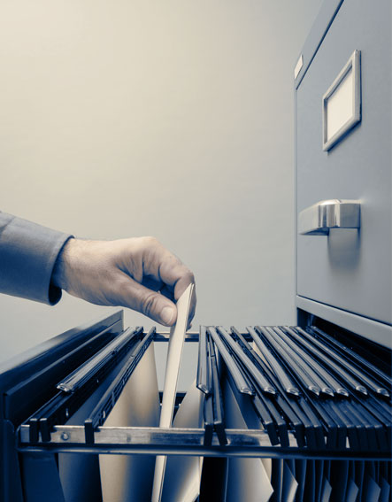 A person filing documents in a filing cabinet