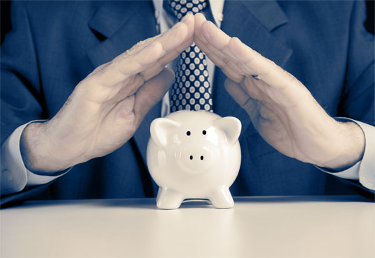 Business Man shielding a piggy bank
